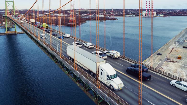 Aerial view of a semi-truck crossing a suspension bridge.