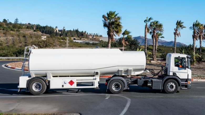 A parked single-axle semi-truck with a white tank