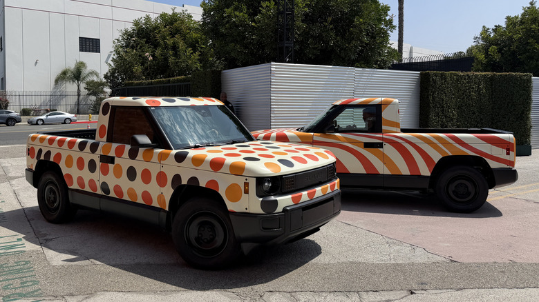 Two colorfully wrapped Slate trucks driving past each other