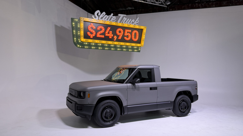 A Slate pickup in front of a sign with the price on it