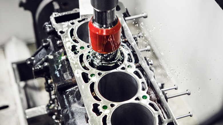 A CNC machine bores out an engine block's cylinder