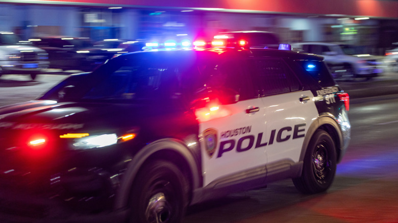 Stock image of a Houston PD cruiser in motion with sirens on.