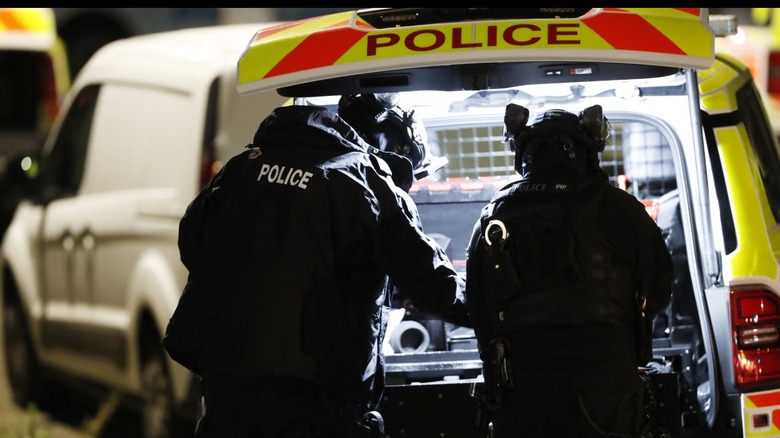 Police getting gear out of the trunk of their vehicle
