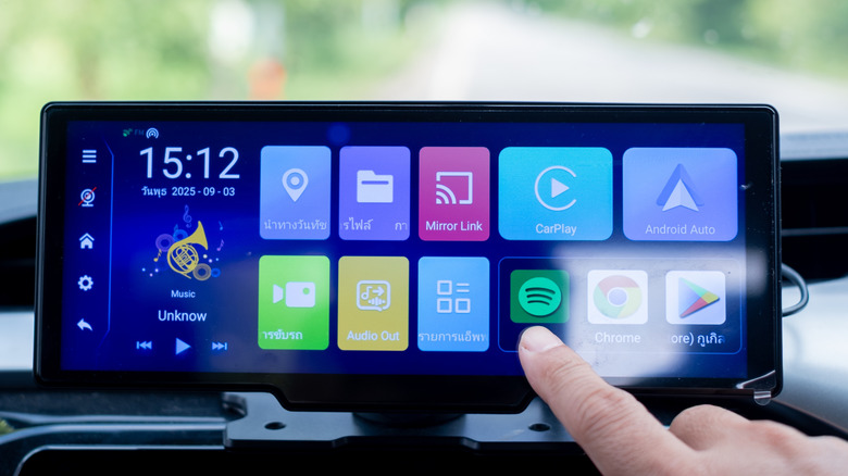 Person touching a car's infotainment touch screen.