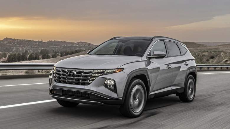A Hyundai Tuscon Plug In Hybrid driving down a road in the american southwest under a stormy sky