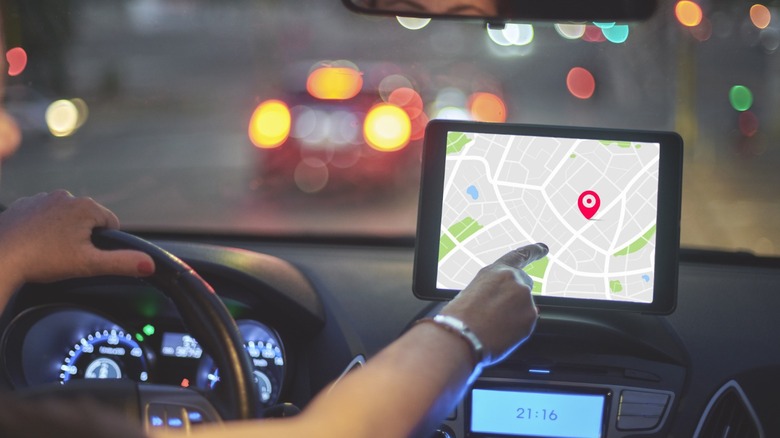 Woman operates navigation app connected touchscreen successful car