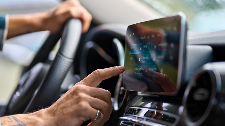 Man's manus operates touchscreen wrong a car