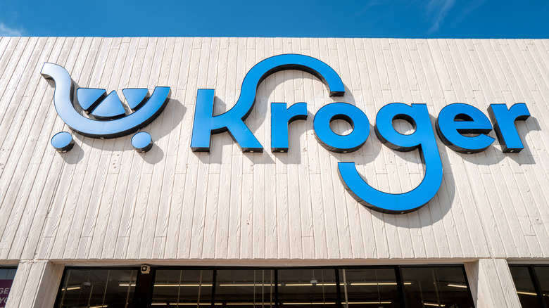 A sign saying "Kroger" with a shopping-cart logo on a Kroger grocery store