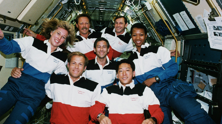 The crew of the shuttle Endeavor on STS-47. Jay Apt is center. Clockwise from right is Dr. Mae Jemison, Mamoru Mohri of Japan, Mark Lee, and his wife Dr. N. Jan Davis, Robert "Hoot" Gibson, and Curtis Brown.