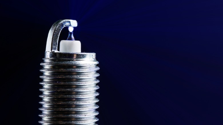 Spark plug producing a spark between the center and side electrode