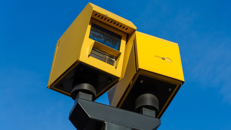 A yellow traffic speed camera box pictured under clear blue skies.