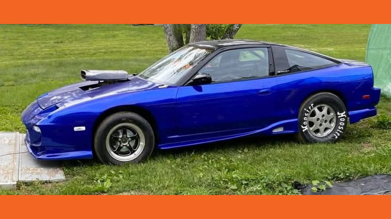 A blue Nissan 240SX hatch with a blower out the hood