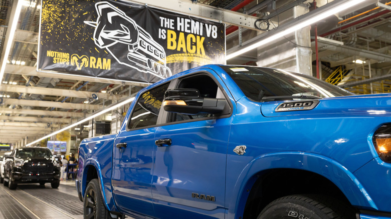 A 2026 Ram 1500 on the assembly line under a banner celebrating the return of the Hemi V8.