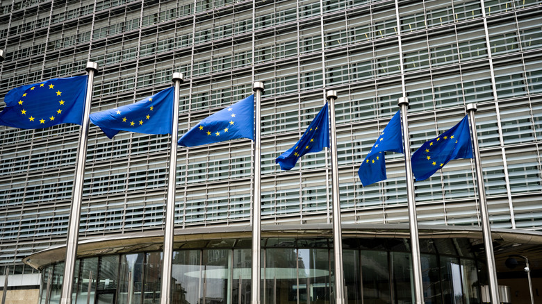 Eu Flags Against European Commission Building Background In Brussels Belgium