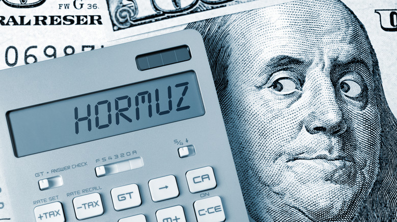 Stock image of Ben Franklin looking at a calculator that says 