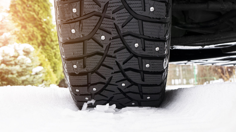 A studded tire on a snowy path