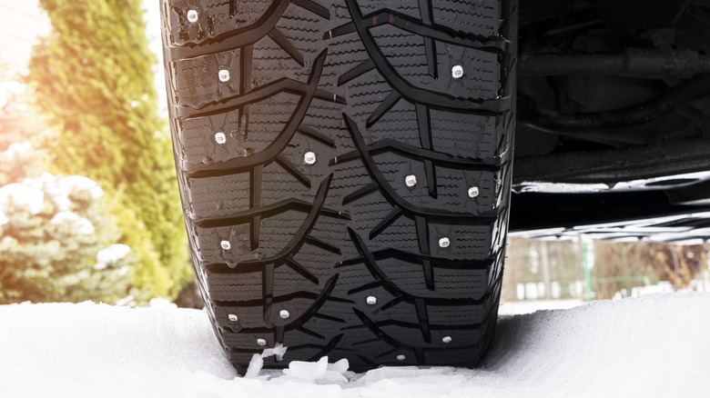 A studded tire on a snowy path