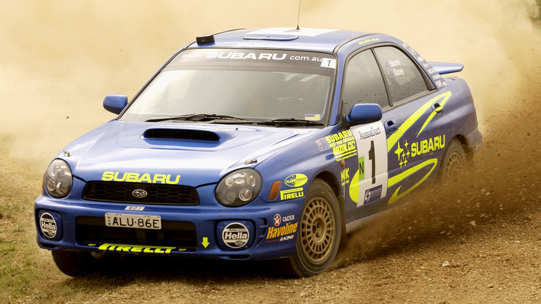 A 2002 Subaru WRX rally racing car sliding through a turn