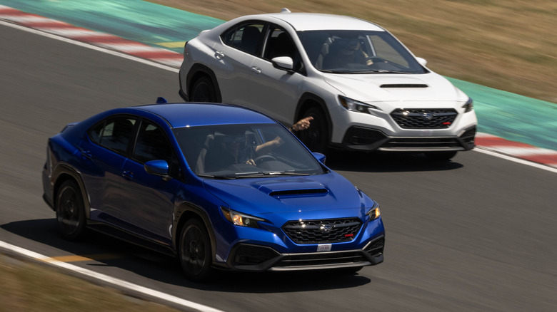 An overhead shot of a blue WRX pointing a white WRX past on the race track