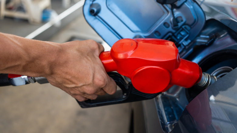 A man filling up his conveyance pinch gas.