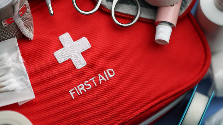 A red first aid kit and some of its contents.