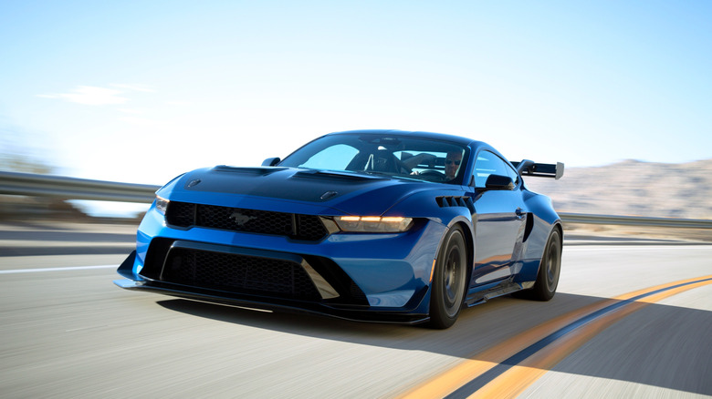 A blue Ford Mustang GTD in motion on a winding canyon road