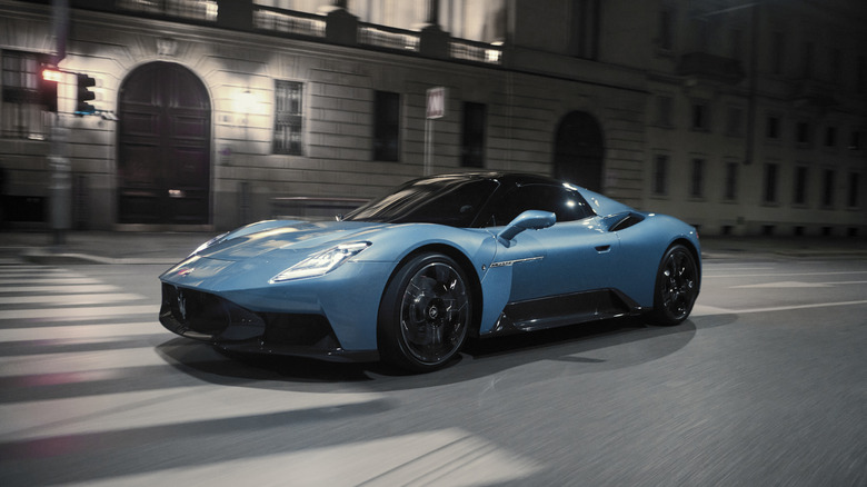A cyan blue Maserati MCPura Cielo (convertible) captured with motion blur on a city street at night