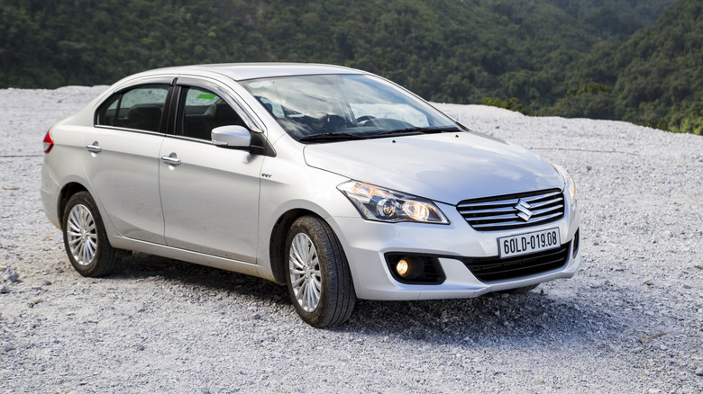 A silver Suzuki Ciaz by a cliffside
