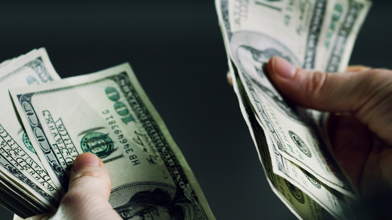 Person counting money they saves by switching auto insurance providers
