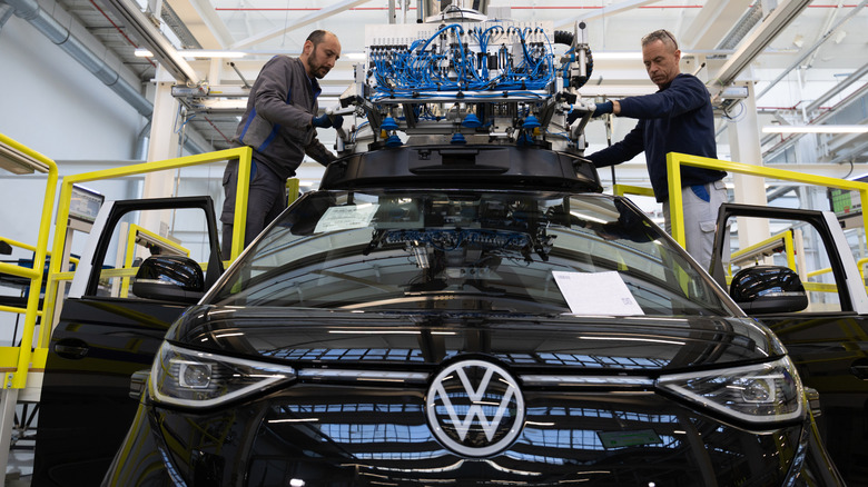 HANOVER, GERMANY - MARCH 4: Workers install the roof sensors, the LIDAR system used as one part for autonomous driving, of the VW ID. Buzz Autonomous Driving (AD) electric van at the Volkswagen commercial vehicles van and bus factory on March 4, 2026 in Hanover, Germany. Volkswagen, Germany's biggest car maker, is scheduled to announce financial results on March 10. (Photo by Christian Ender/Getty Images)