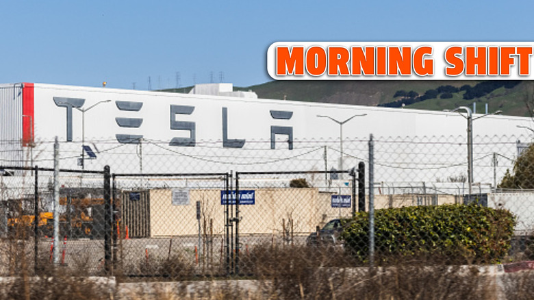 Feb 17, 2020 Fremont / CA / USA - Exterior view of Tesla Factory located in East San Francisco bay area; Large Tesla logo displayed on one of the buildings visible behind a fence