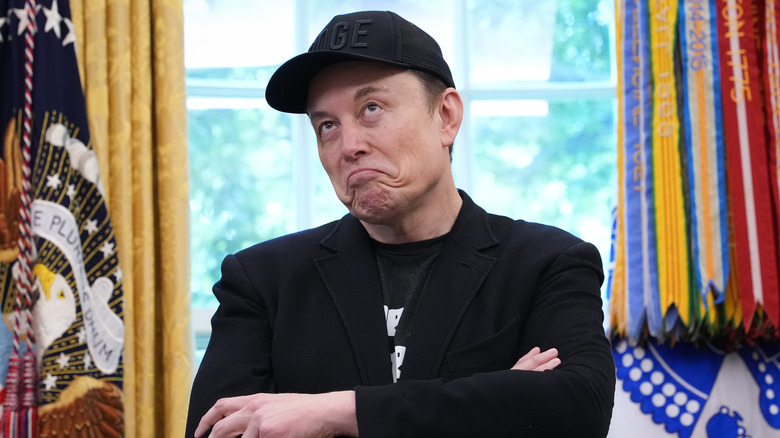 Elon Musk with his right arm extended straight to the tips of his fingers, his face covered with the Grok logo and the pulpit logo covered with that of xAI