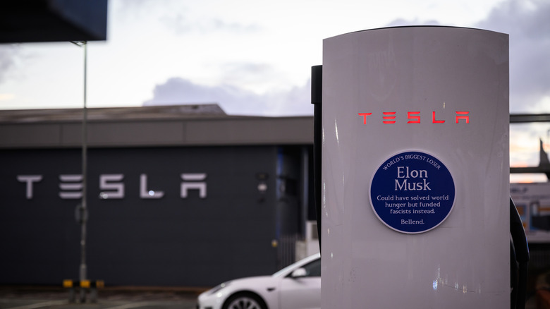 LONDON, ENGLAND - NOVEMBER 06: A fake heritage plaque, reading "Elon Musk could have solved world hunger but funded fascists instead" is displayed on a charging station at a Tesla dealership on November 06, 2025 in London, England. Tesla shareholders are in the process of voting on a new reward package for Elon Musk that could see him own over 25% of company stock, making him the world's first trillionaire. The activist group Everyone Hates Elon has created a series of posters and public artworks in recent months critical of Elon Musk, as well as other business and political leaders.