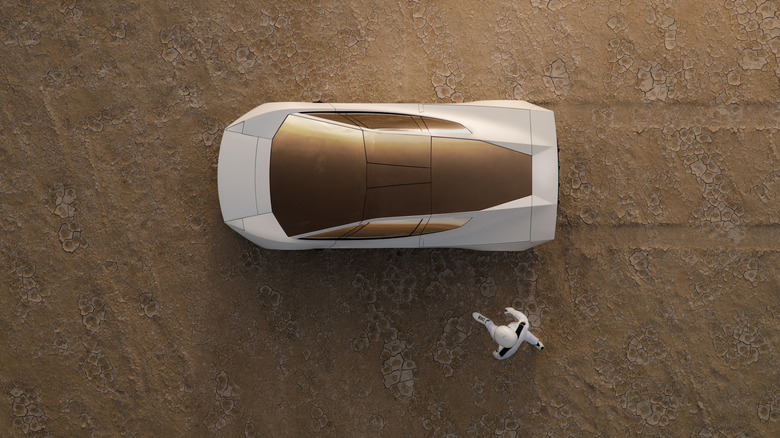 Person in space suit approaches Roadster in a desert