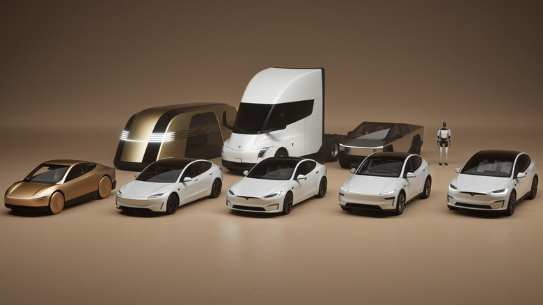 A wide shot of Tesla's full lineup of concept vehicles and production vehicles as well as its robot in front of a tan background