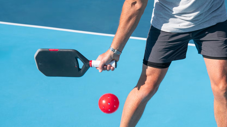 A person swinging a Tesla Plaid Paddle at a pickleball