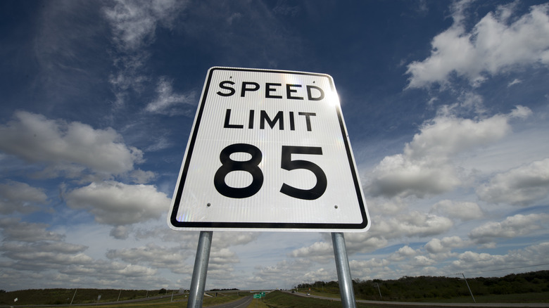 A traffic sign displaying a speed limit of 85 mph.