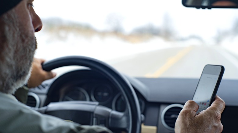 A distracted driver using his phone while driving