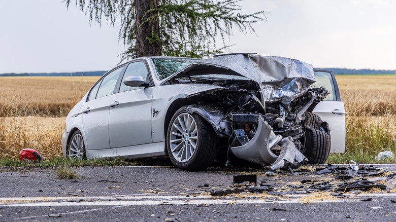 A crashed silver BMW by the side of the road