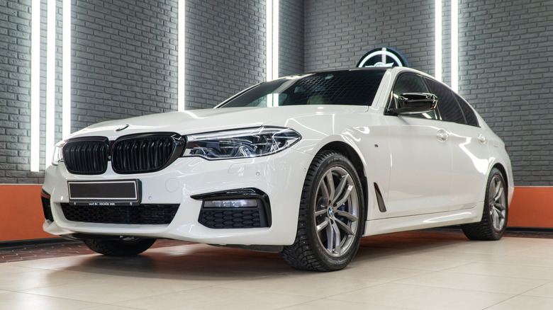 White BMW 5 Series parked in a showroom.