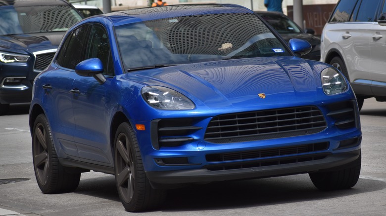 Blue Porsche Macan driving in traffic.