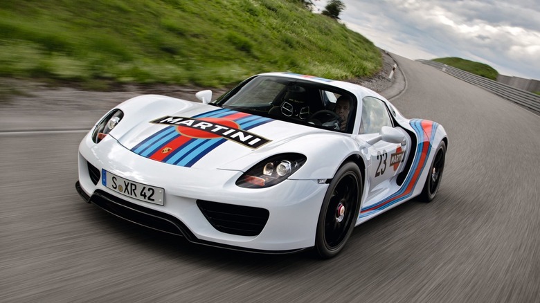 A Porsche 918 Spyder wearing the iconic Martini Racing livery mid-corner on a track.