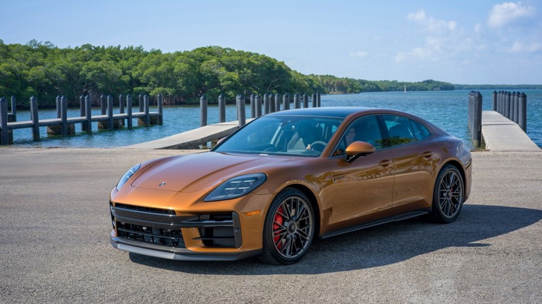 A Porsche Panamera Turbo E-Hybrid in a rich copper metallic finish parked on a pier.