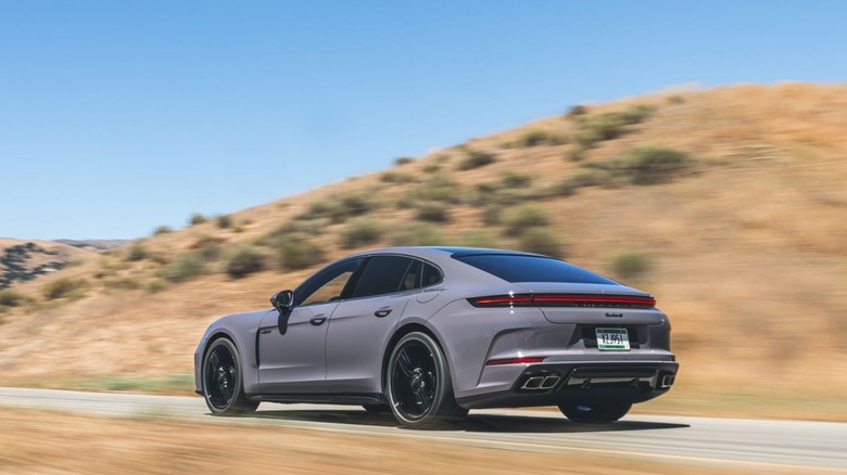 A gray Panamera Turbo S E-Hybrid cruising through a golden-hued mountain pass,.