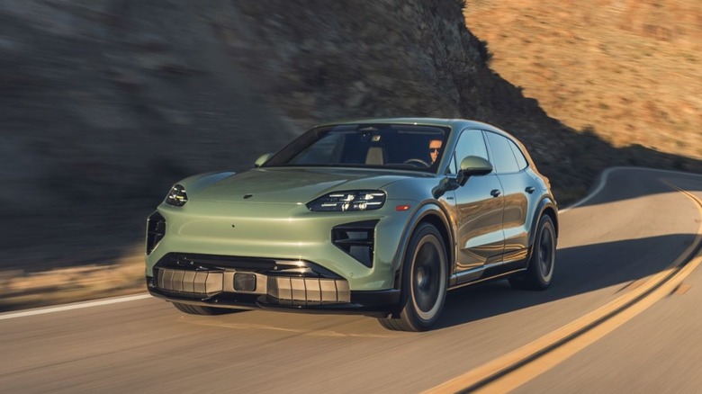 A Cayenne Turbo Electric in a soft metallic green finish navigating a winding canyon road.