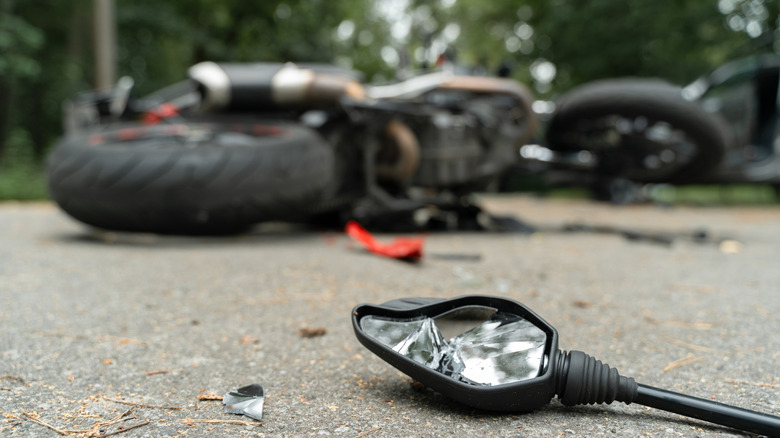 Broken and wrecked motorcycle on the road after an accident.