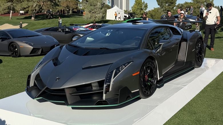 A grey Lamborghini Veneno on the stand at a car show
