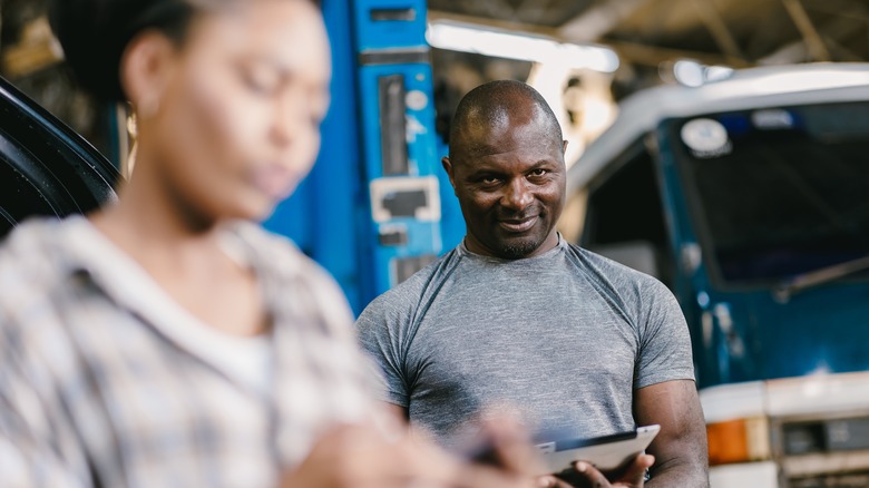 A mechanic smirks arsenic a customer gets fresh to salary nan bill.