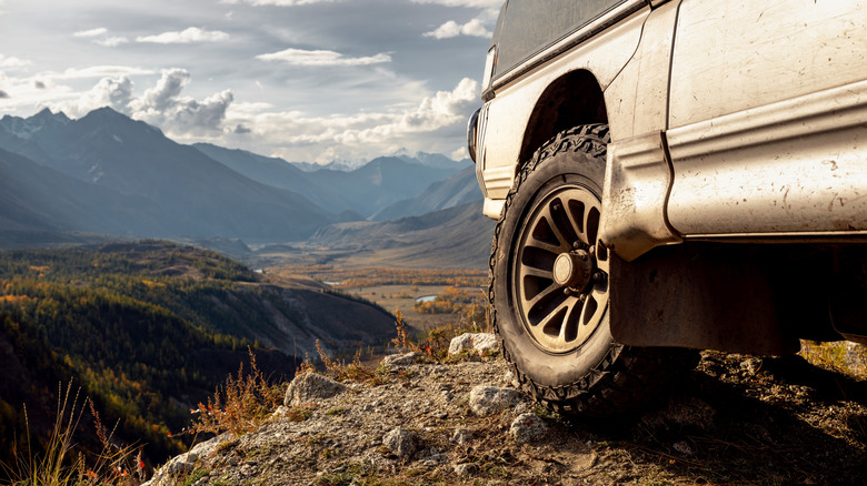 Close-up of a 4x4 tire with a picturesque background.