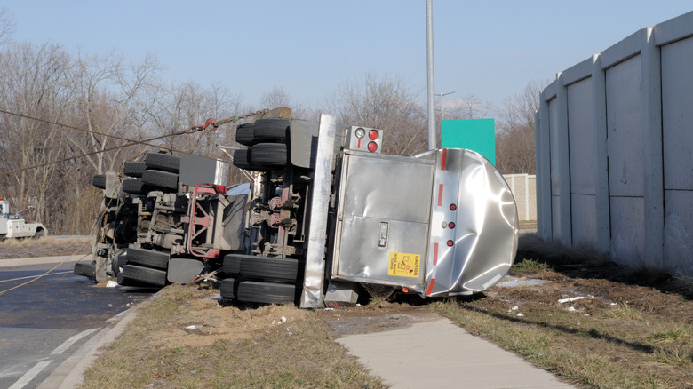 An overturned semi-truck on the side of a road